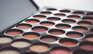 A makeup palette with a variety of round color shades arranged neatly.