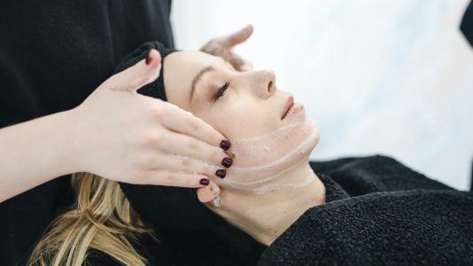 Hands applying a cream on a person's hand, focusing on skincare and massage techniques.