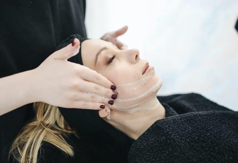 Hands applying a cream on a person's hand, focusing on skincare and massage techniques.